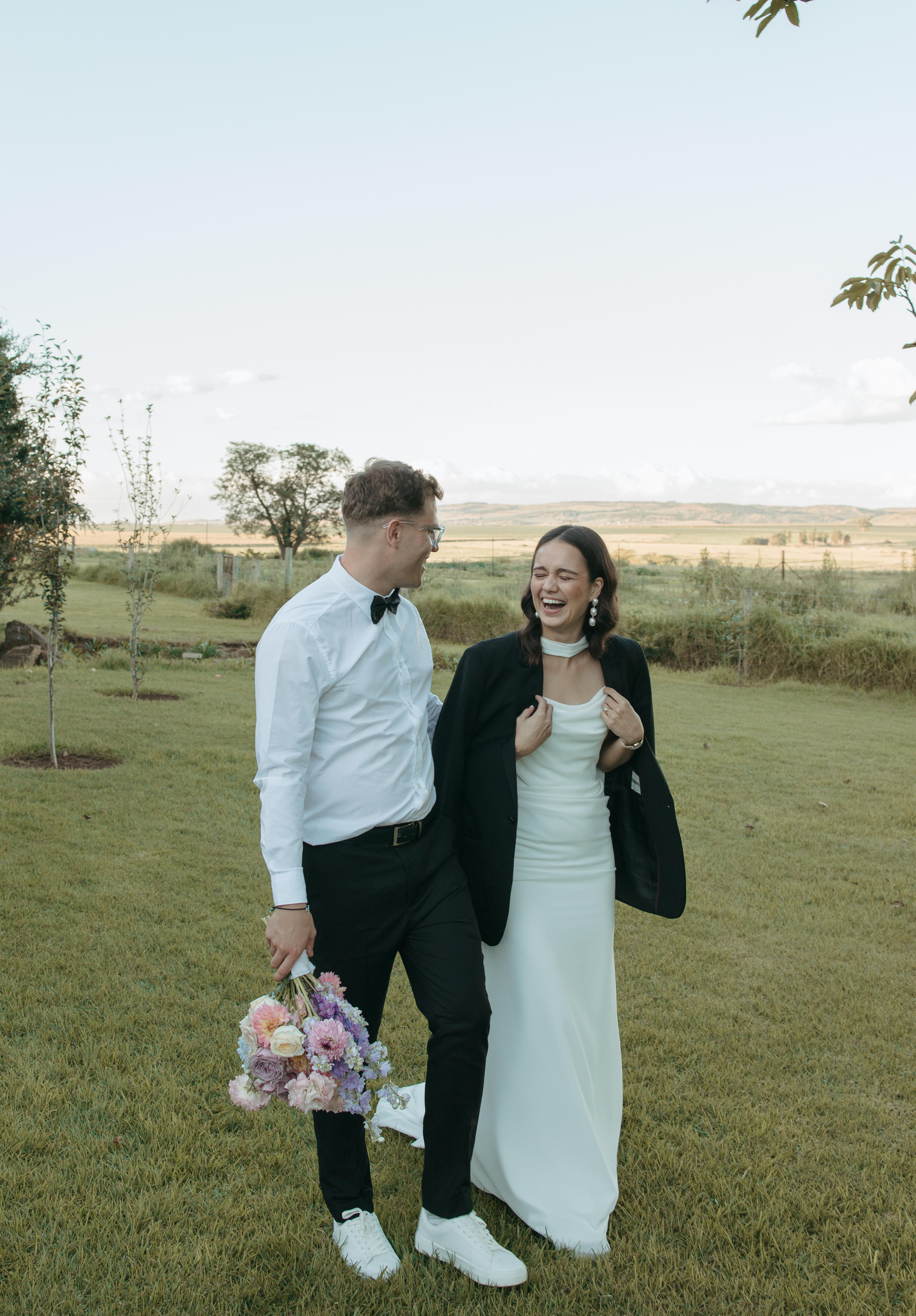 Couple sharing a laugh on the farm at golden hour